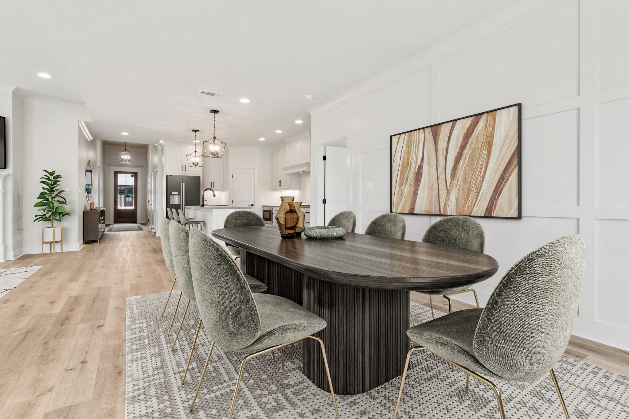 A modern dining room with a dark wood oval table, eight gray upholstered chairs with gold legs, abstract wall art, and an open view to a white kitchen with pendant lights. Light wood floors and neutral decor create an airy feel.